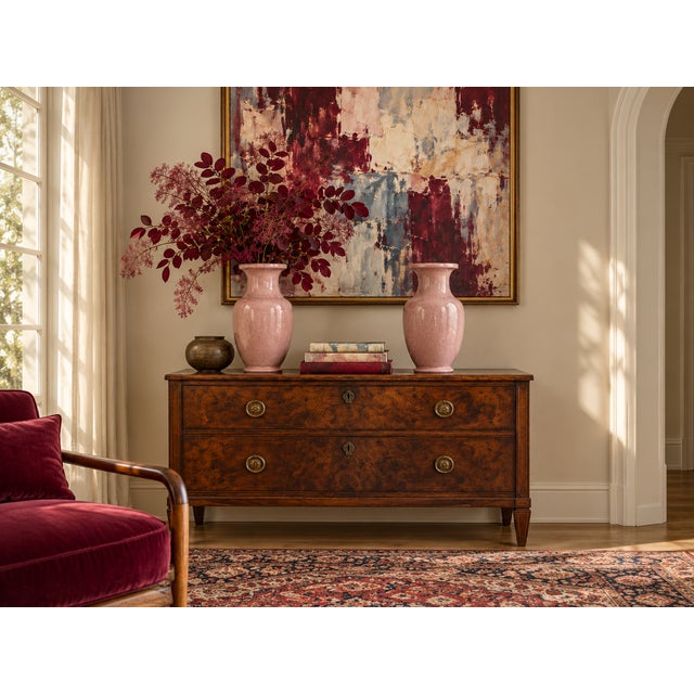 A striking matched pair of tall ceramic vases finished in a soft blush-pink crackle glaze. The dense network of fine...