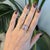 A 5.93-carat rainbow moonstone cabochon glows with a floating blue adularescence at the centre of this solid 14K rose gold...