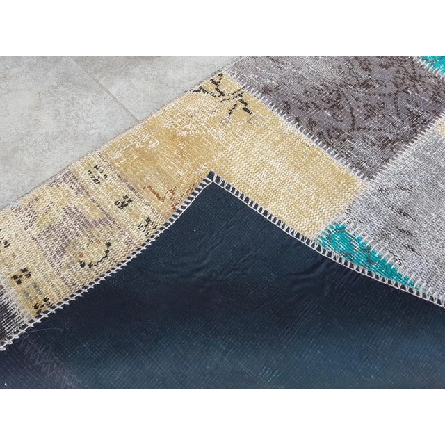 This is a vintage Turkish Oushak rug from the Mid 20th Century. The piece was hand-knotted.