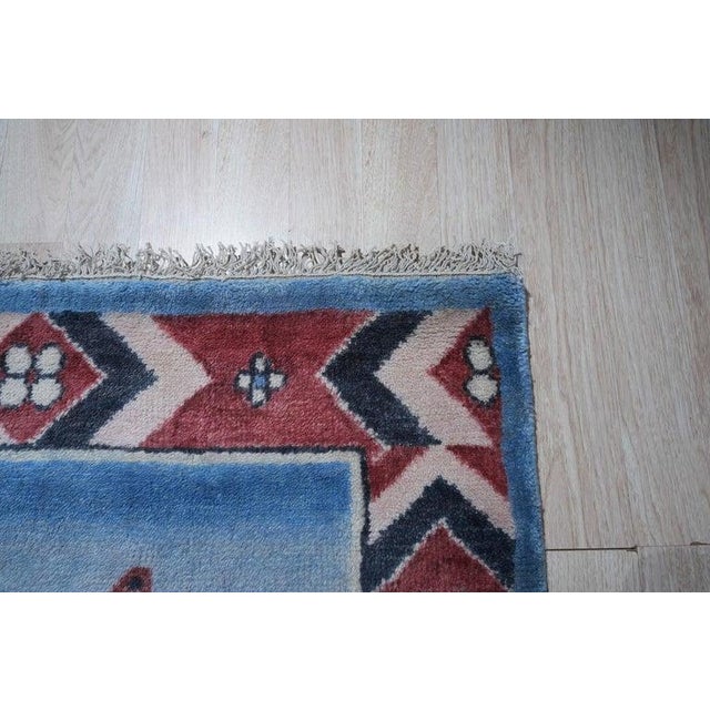 This blue wool rug functions as a durable hand knotted pile floor covering designed in the Oushak style. Produced in...
