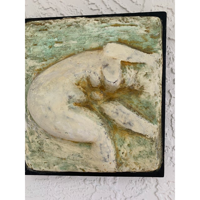 A vintage mixed-media low relief fiberglass sculpture depicting a stylized crouching nude female. The sculptural form...