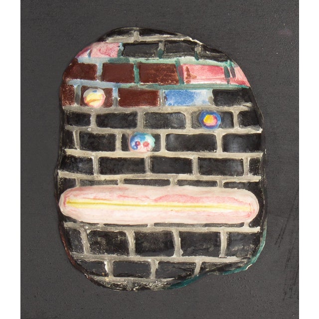 A 1970s ceramic tile by the American artist Mark Bulwinkle (born 1946). This ceramic piece depicts an abstract face...