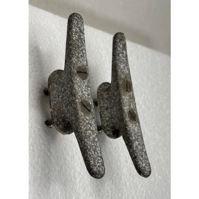 These objects once cast iron boat dock cleats and once commonly used for mooring small crafts have been repurposed as a...
