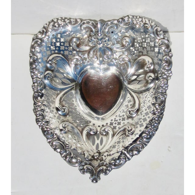 Gorham Sterling Chantilly heart-shaped pierced wall bowl. Raised on 3-ball feet and rolled over rim design. The pattern...