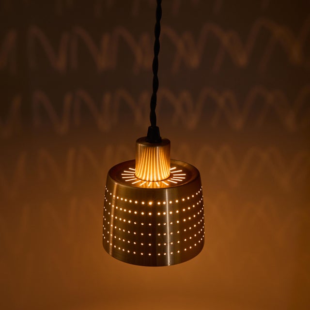 1950s Carl Thore Perforated Brass Pendant Executed in perforated brassed metal with an attractive patina, this sculptural...