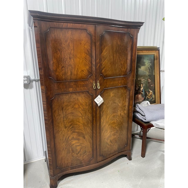An early 20th century two door armoire of figured mahogany by Waring & Gillow of Lancaster, England. This armoire has a...