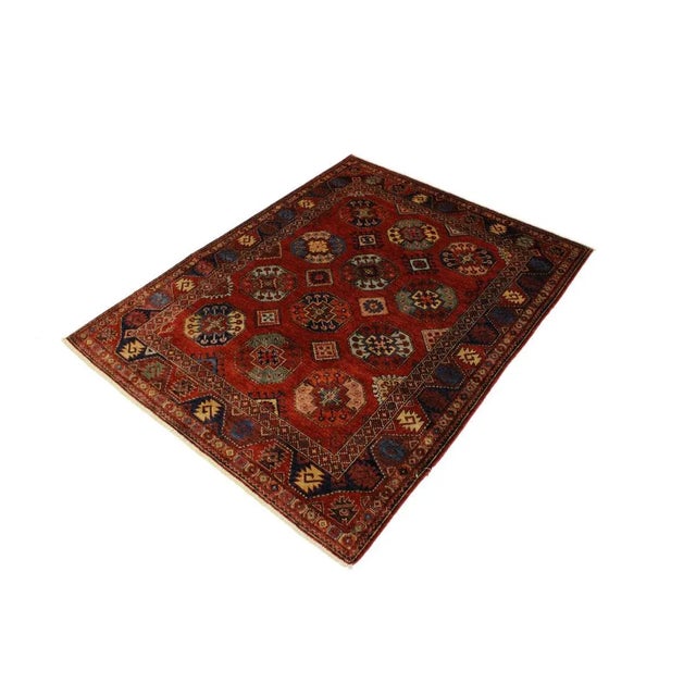 An invigorating oriental rug with distinctive motifs and wide-ranging pallet of warm colors, this geometric hand knotted...
