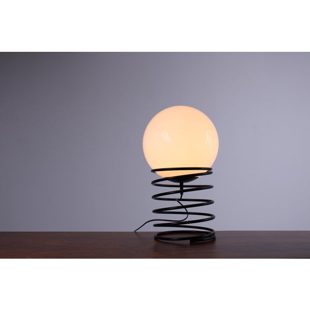 A large black and white pop-art lamp (51 cm high), suitable as a table or floor lamp. A metal spring coil holds an opal...