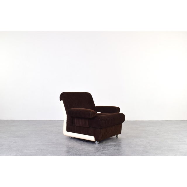 This armchair was manufactured in Germany in the 1970s. The seat and backrest are upholstered in the original, thick beige...