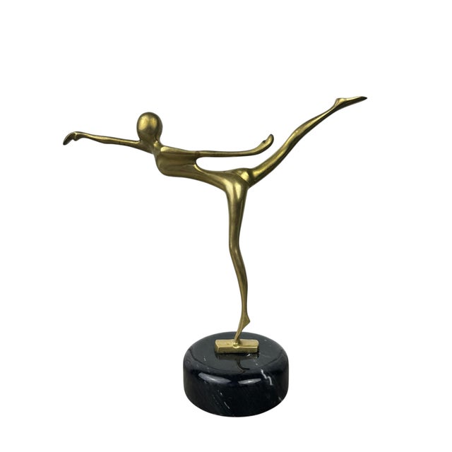Vintage brass dancer figurine in an arabesque pose, elevated on a marble base.