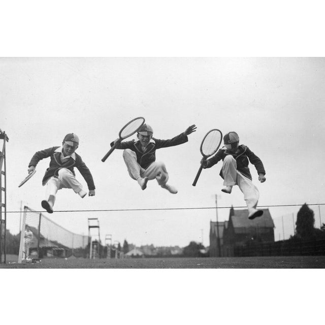Tennis Leap 22nd August 1932: Three young competitors leaping over the boundary between two tennis courts at the Essex...