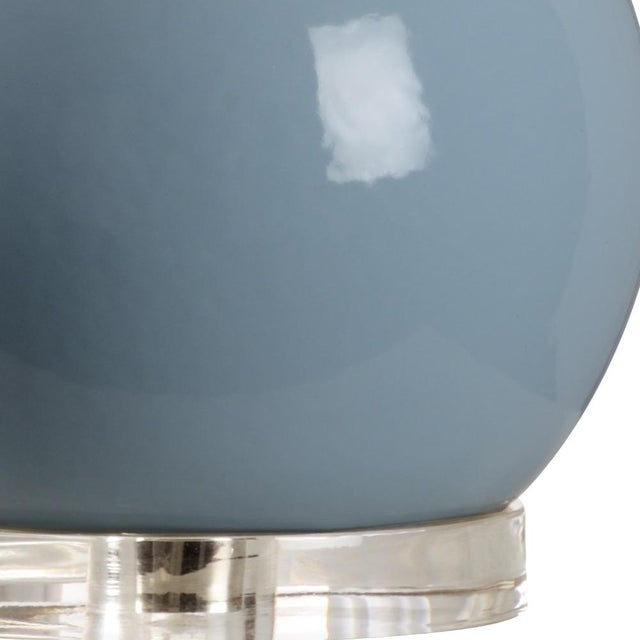 Provide accent lighting with this modern bottle style table lamp. A soothing sky blue glazed ceramic with silver leaf neck...