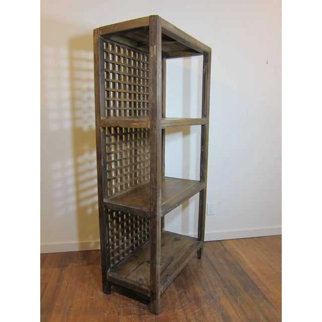 Antique rustic bookcase made of elm wood. Lattice style screened back. The elm wood is worn and faded, natural showing its...