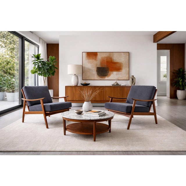 Experience the timeless elegance of mid-century modern design with these expertly crafted walnut lounge chairs, made in...