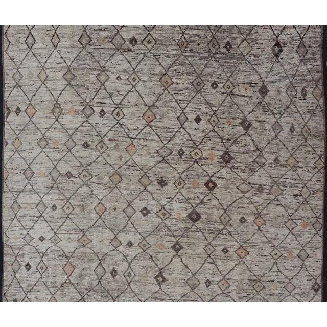 Measures: 10'1 x 13'7. This modern casual tribal rug has been hand-knotted. The rug features a modern sub-geometric all-...