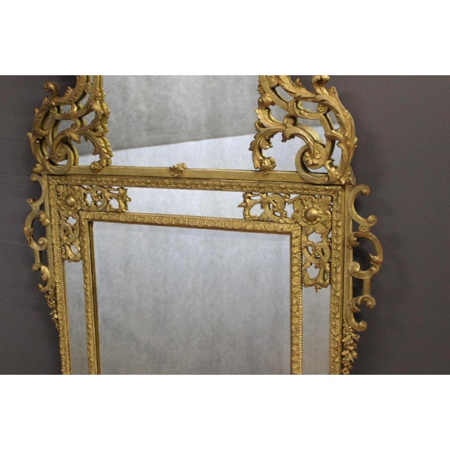 Regency mirror with gilt and carved wooden side panels, double-framed with moldings known as "Bérain" moldings, decorated...