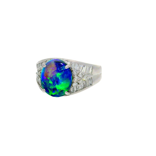 A striking and contemporary ring featuring a 2.57 carat black opal. It displays a captivating rainbow color with a smooth...