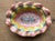Colorful hand-painted ceramic plate by MacKenzie-Childs, featuring the brand’s signature whimsical aesthetic and...