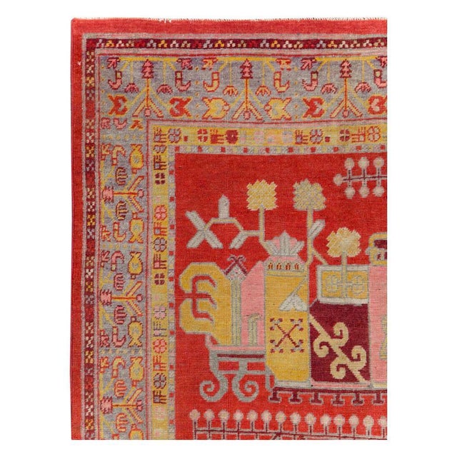 An antique East Turkestan Khotan small gallery rug handmade during the early 20th century with a pictorial vase design...