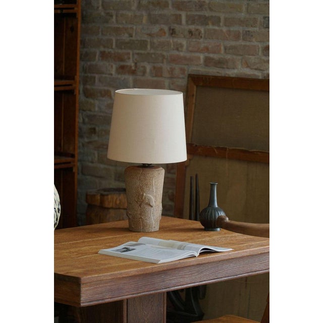 A charming mid century table lamp in stone. Made in France in the 1970s. The lamp features a unique stone base adorned...