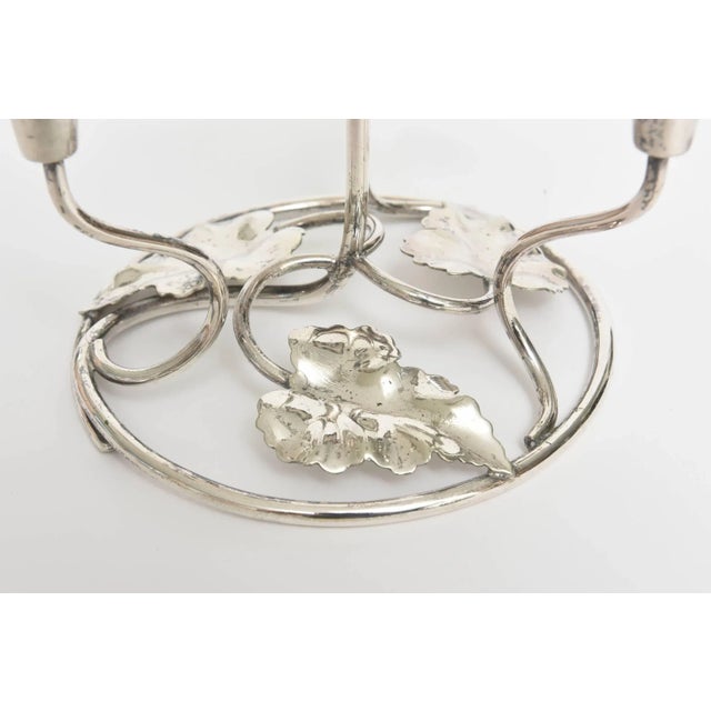 Silver plated four candle stick with leave design on circular based. Includes four tapers or four flower trumpets with...