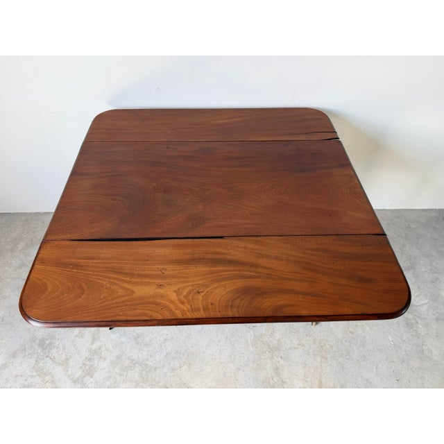 A beautiful antique English Regency Pembroke table crafted from solid mahogany, showcasing elegant proportions and...