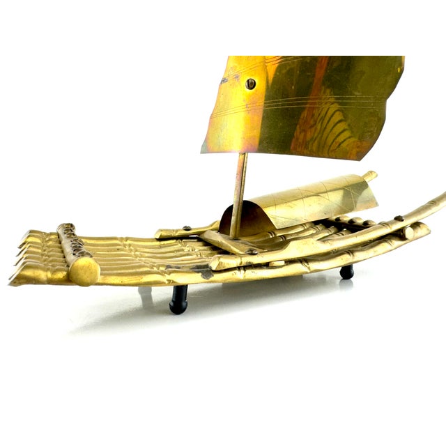 A striking mid-century brass sculpture depicting a stylized Asian sailboat with rich patina and strong sculptural...