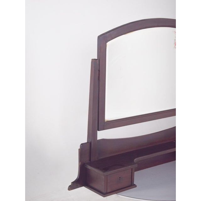 Dressing table mirror with two drawers. In dark wood with a robust structure and restrained design. The mirror frame has a...