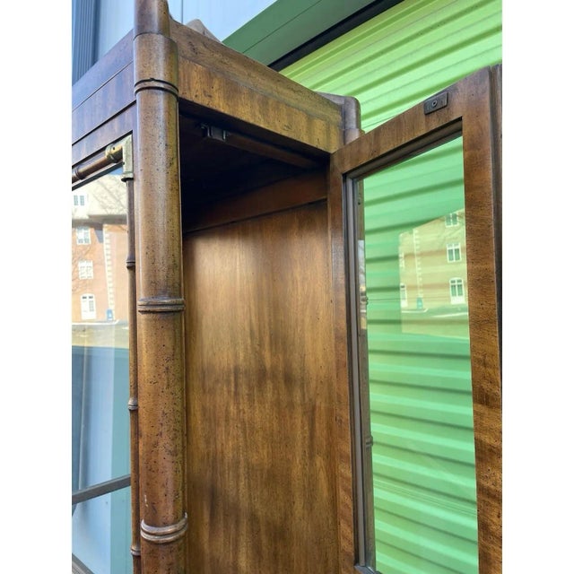 Offered is a vintage pagoda style display cabinet by Weiman. This piece is illuminated from the top with doors on each...