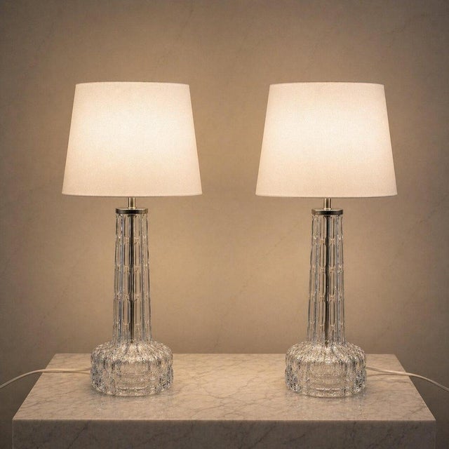 Elegant pair of mid-century modern crystal table lamps designed by Carl Fagerlund for Orrefors, Sweden, circa 1960s. These...