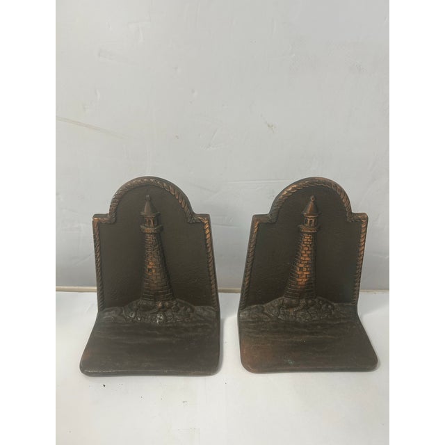 Beautiful pair of cast iron with copper bookends with a nautical lighthouse theme. The coastal reference is also reflected...
