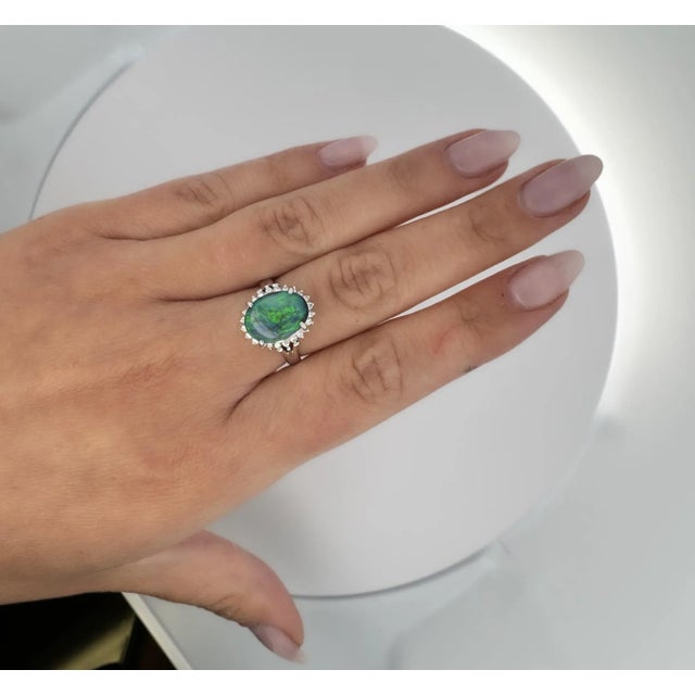 2.78 carat natural black opal and round cut diamond halo ring. Set in a smooth textured platinum 900 ring setting. The...