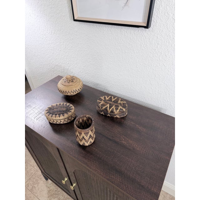 A beautifully curated, 4-piece collection of vintage mid-century hand-woven decorative baskets. Masterfully crafted using...