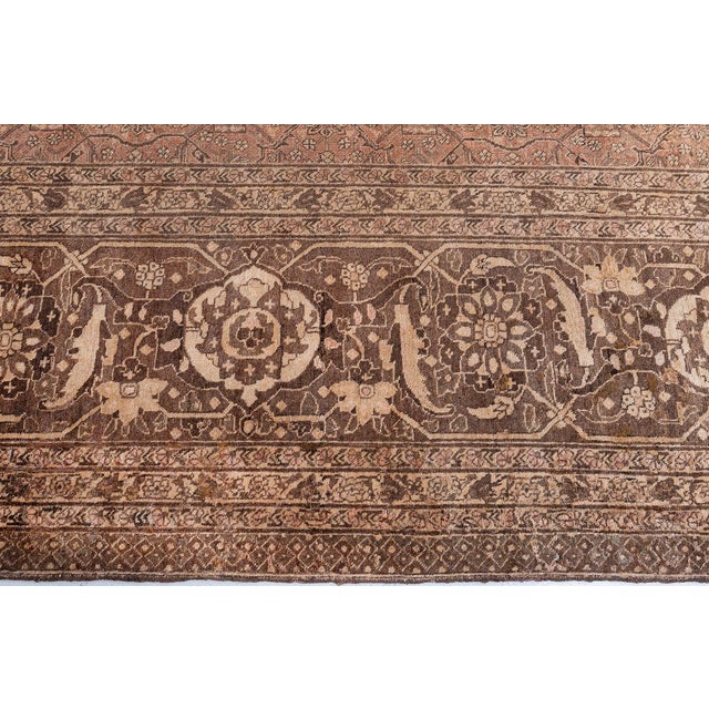 Steeped in elegance and craftsmanship, this exquisite oversized antique Persian Tabriz rug from the 1920s embodies the...