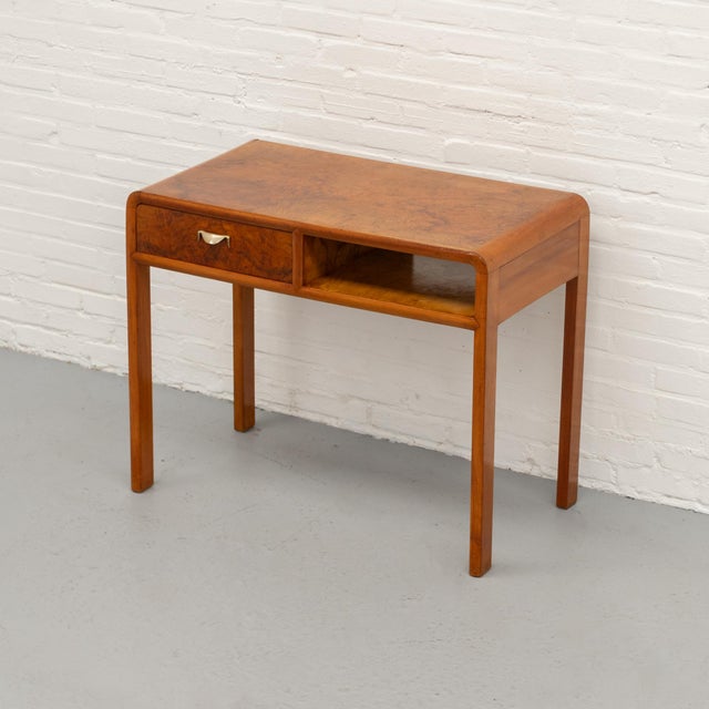 Italian Art Deco desk from circa the 1930s/40s, crafted in warm wood with richly figured burl veneer. The top and drawer...