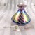 This is a purple and white unmarked perfume bottle. It has a lot of iridescent colors in a puled feather design. It comes...
