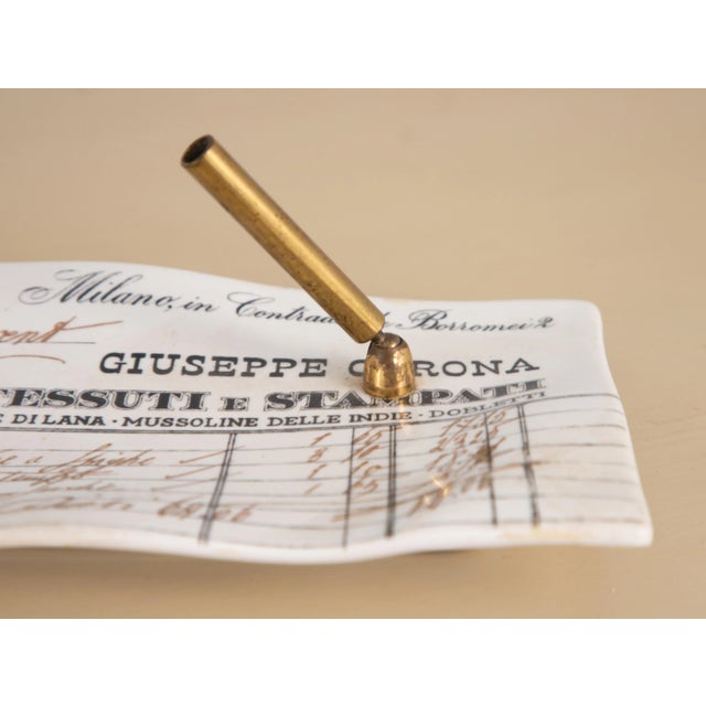 A vintage Fornasetti porcelain desk tray with brass pen holder. It has the appearance of a crumpled receipt with historic...