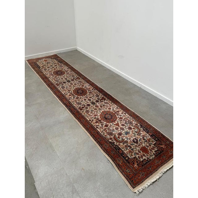 Beautiful long vintage runner rug with an exceptionally detailed traditional Oriental design. The rug features a warm...