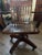Solid oak vintage office/desk armchair featuring a slat back, contoured wood seat, armrests, four-leg caster base, and...