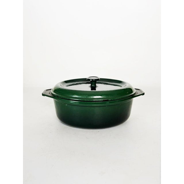 Vintage green enameled cast iron casserole dish, typical of the robust and durable cookware of the 1970s. Featuring a...