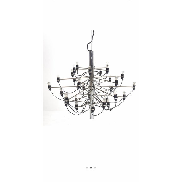 From Arteluce circa 1958 designed by Gino Sarfatti. A cylindrical shape plated metal chandelier. The central stem has...