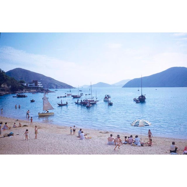 A Hong Kong Beach 1959 Families enjoy a day at the beach in Hong Kong with traditional junks and other boats lying...