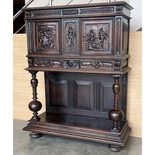 20th century Spanish hand carved Renaissance raised cabinet was rendered from dense, old-growth quarter sawn walnut,...