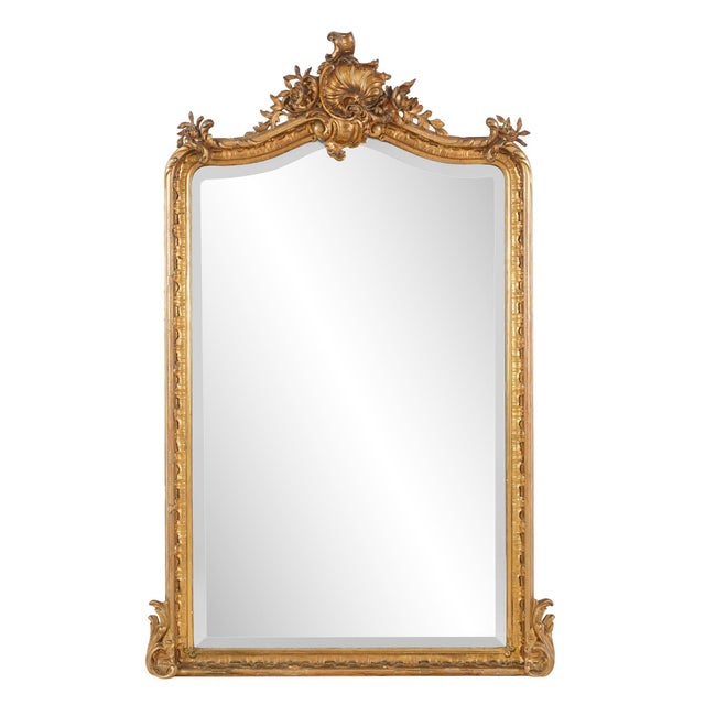 Antique French made Louis XV style wall mirror with Rococo influences in the shell motif, elaborately curling foliage, and...