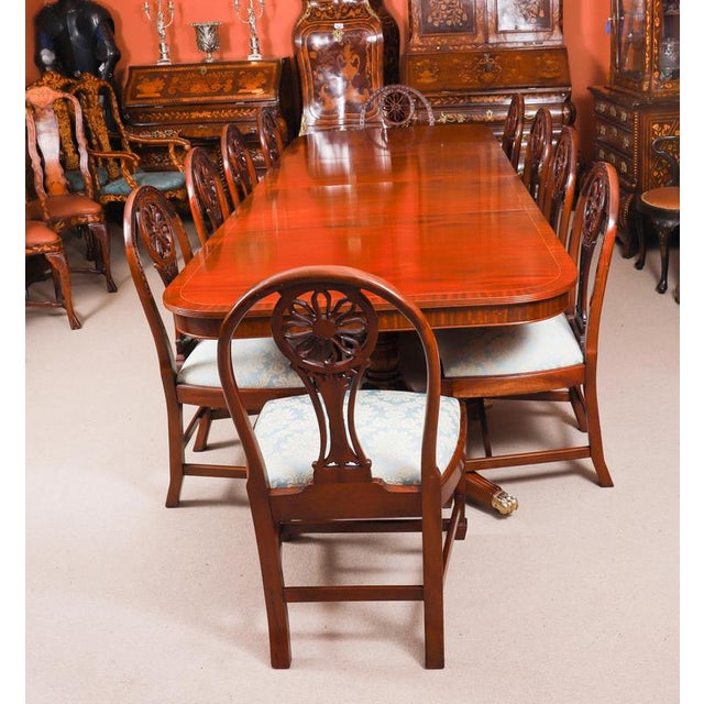 This is a fabulous high quality antique flame mahogany Regency revival twin pillar dining table and a set of ten Regency...