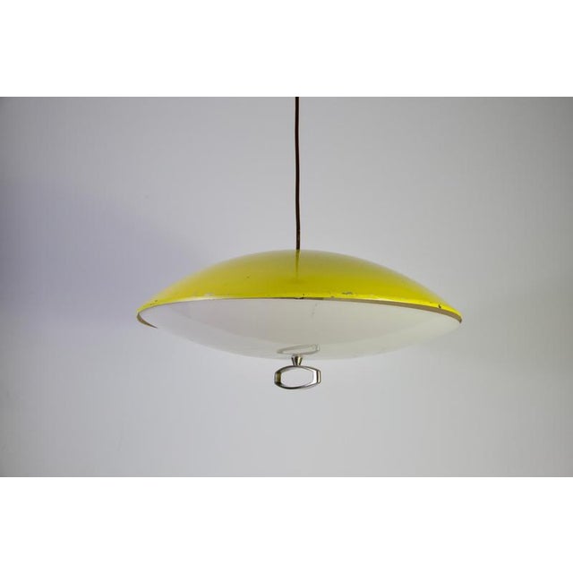 Yellow italian pendant lamp, 1950s. This elegant vintage ceiling light features a shallow saucer-shaped metal shade in...