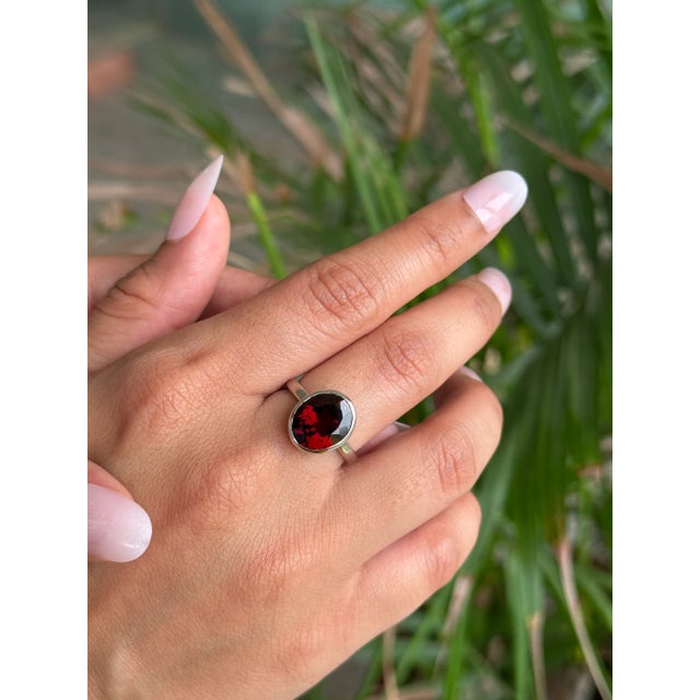 Crafted in 925 Sterling Silver, this garnet solitaire ring showcases a rich oval-cut gemstone in a sleek bezel setting....