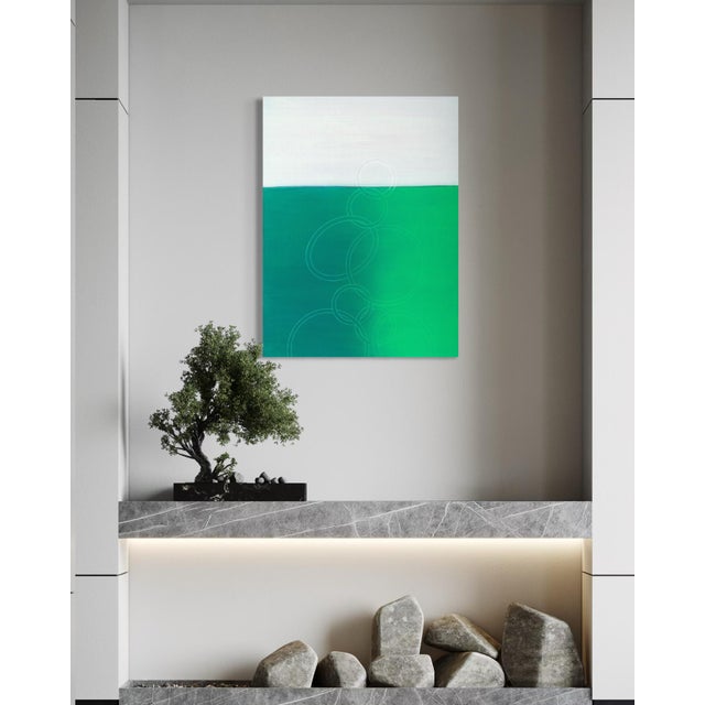 A soft, misted grey sky sits above a rich, saturated field of emerald green, the two halves blending together at a hazy...