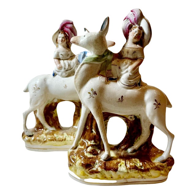 A charming pair of Staffordshire figurines featuring girls seated on deer. Staffordshire pottery has a rich history,...