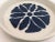 Wheel thrown pottery glazed with a white glaze decorated with a hand painted blue flower pattern. This is a one of a kind...